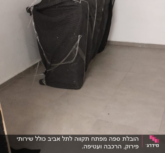 רהיט עטוף בשמיכה שחורה עם גלגלים
